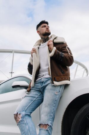 Kożuch męski w brązowym kolorze z białym futrem, z zamkiem i paskiem w talii, idealny na zimowe dni