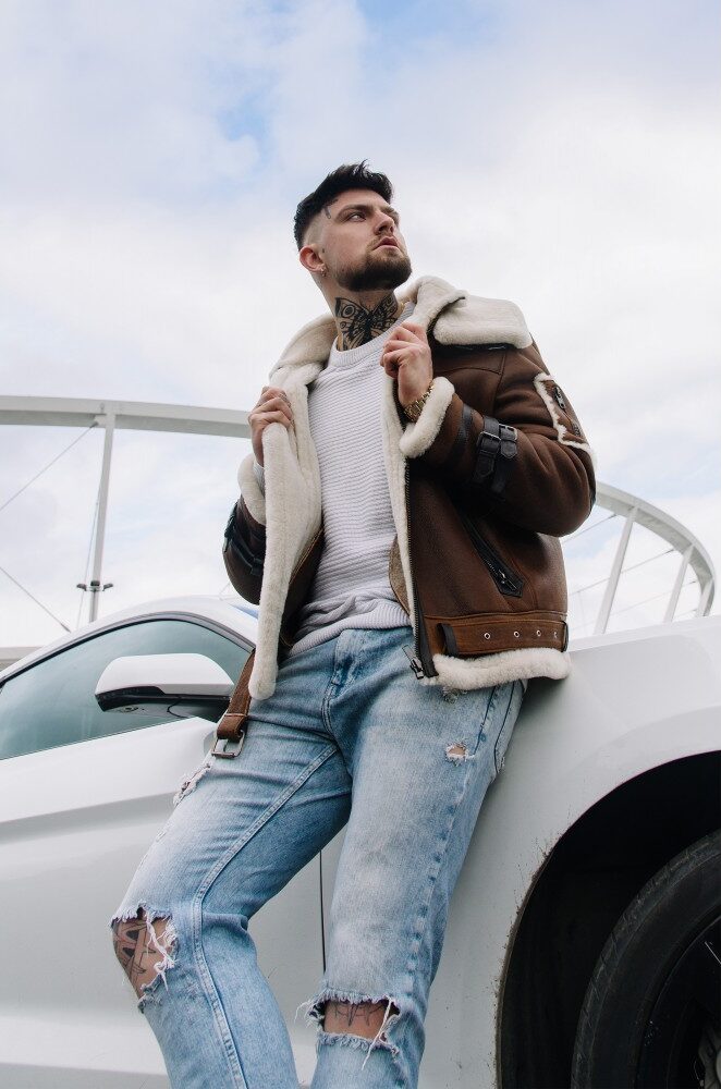 Kożuch męski w brązowym kolorze z białym futrem, z zamkiem i paskiem w talii, idealny na zimowe dni