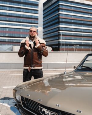 Kożuch męski w kolorze brązowym z białym futrem i zapięciem na suwak, idealny na zimowe dni