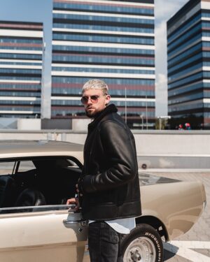 Kożuch męski w czarnym kolorze z futrzanym kołnierzem i kieszeniami na zamek