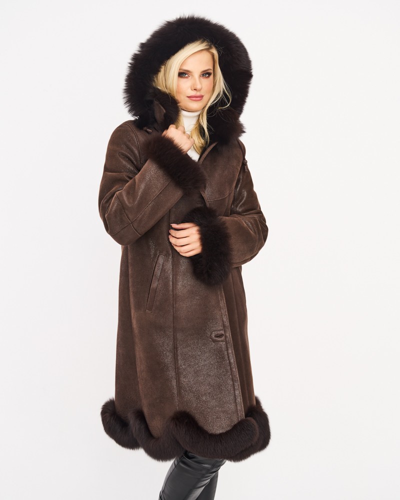 Kożuch damski w ciemnym brązie z dużym futrzanym kapturem i ozdobnym wykończeniem na dole oraz rękawach