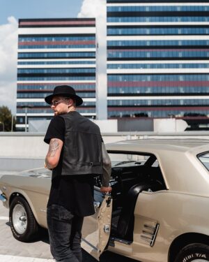 Kamizelka skórzana męska w czarnym kolorze, z krótkim krojem i detalami w postaci paska, stylowy dodatek do casualowej stylizacji