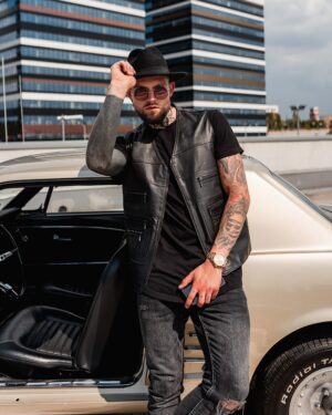 Kamizelka skórzana męska, czarna, z kieszeniami, noszona na czarnym t-shircie, stylowy dodatek do casualowej stylizacji