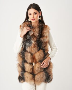 Kamizelka futrzana w odcieniach brązu i czerni, o długim włosiu, noszone na białej bluzce, z eleganckimi dodatkami