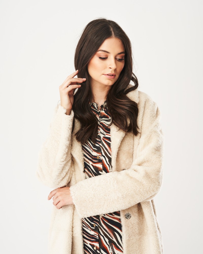 Kożuch damski w kolorze ecru, z miękkim futrem, długim krojem i kołnierzem, idealny na zimowe dni