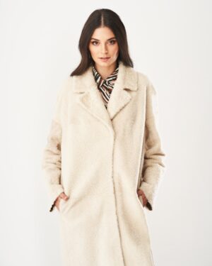 Kożuch damski w jasnym kolorze, o luźnym kroju, z dużymi kieszeniami i klasycznym kołnierzem