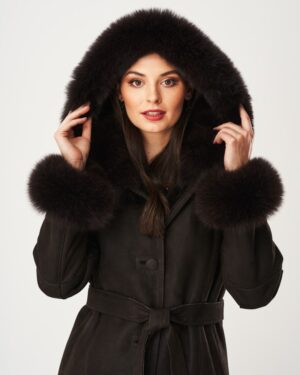 Kożuch damski w ciemnym kolorze z futrzanym kapturem i mankietami, zapinany na guziki z paskiem w talii
