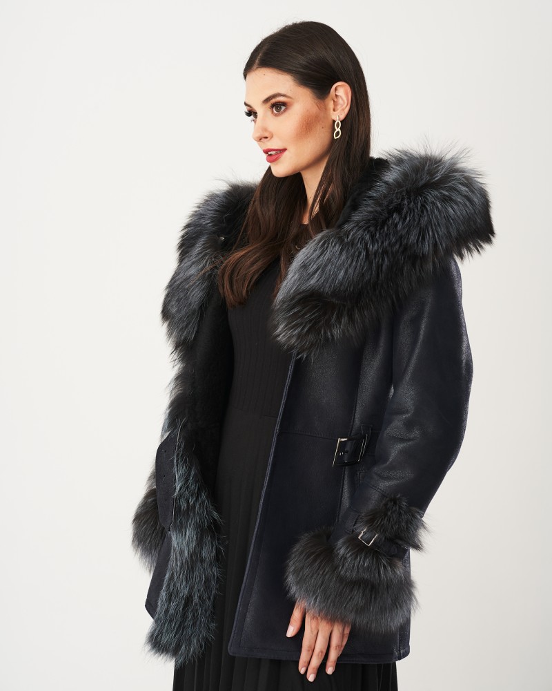 Kożuch damski w ciemnym kolorze z futrzanym kołnierzem i mankietami, zapinany na pasek z klamrą