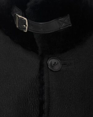 Czarny kożuch damski z wysokim kołnierzem i paskiem, eleganckie guziki oraz miękka tekstura materiału