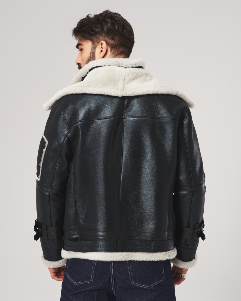 Czarny kożuch męski z białym futrem i szerokim kołnierzem, zapinany na paski z przodu