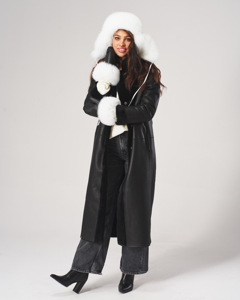 Czarny kożuch damski z białym futrzanym wykończeniem, długim krojem i zapięciem na guziki