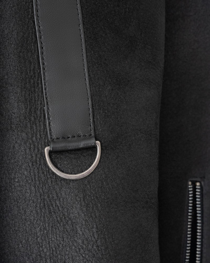 Czarny kożuch damski z eleganckim paskiem i metalowym detalem, idealny na zimowe dni